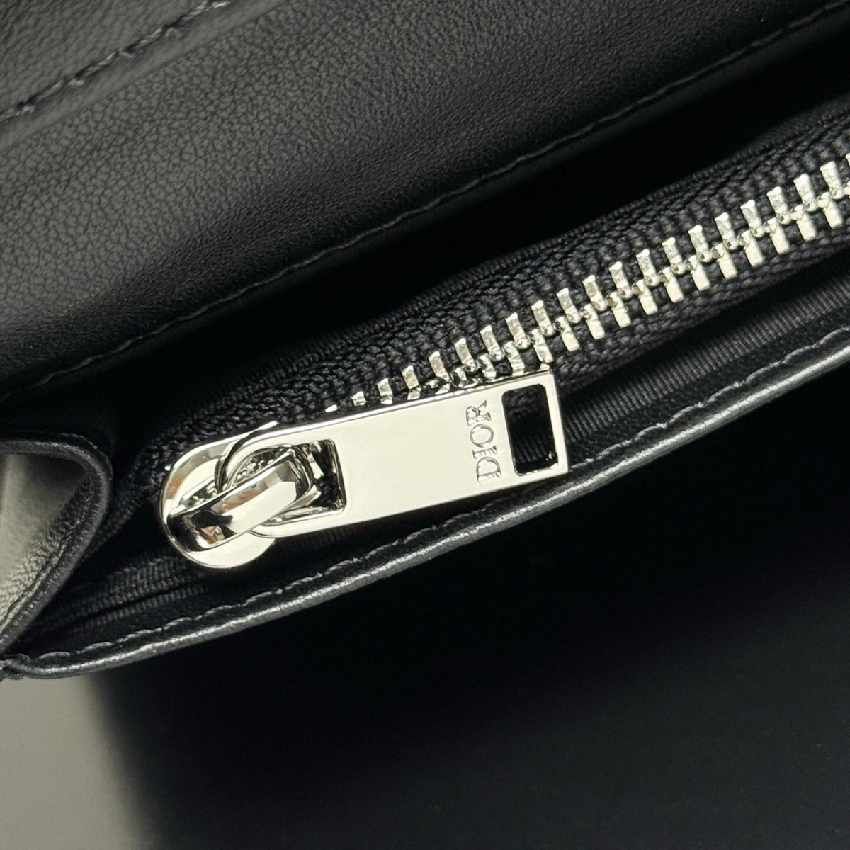 Stylish and functional, this vertical bi-fold wallet is crafted from black grained cow leather. Vertical bi-fold design. CD logo on front for added style. Features five cash compartments, 16 card slots and a zippered coin compartment. Long vertical design