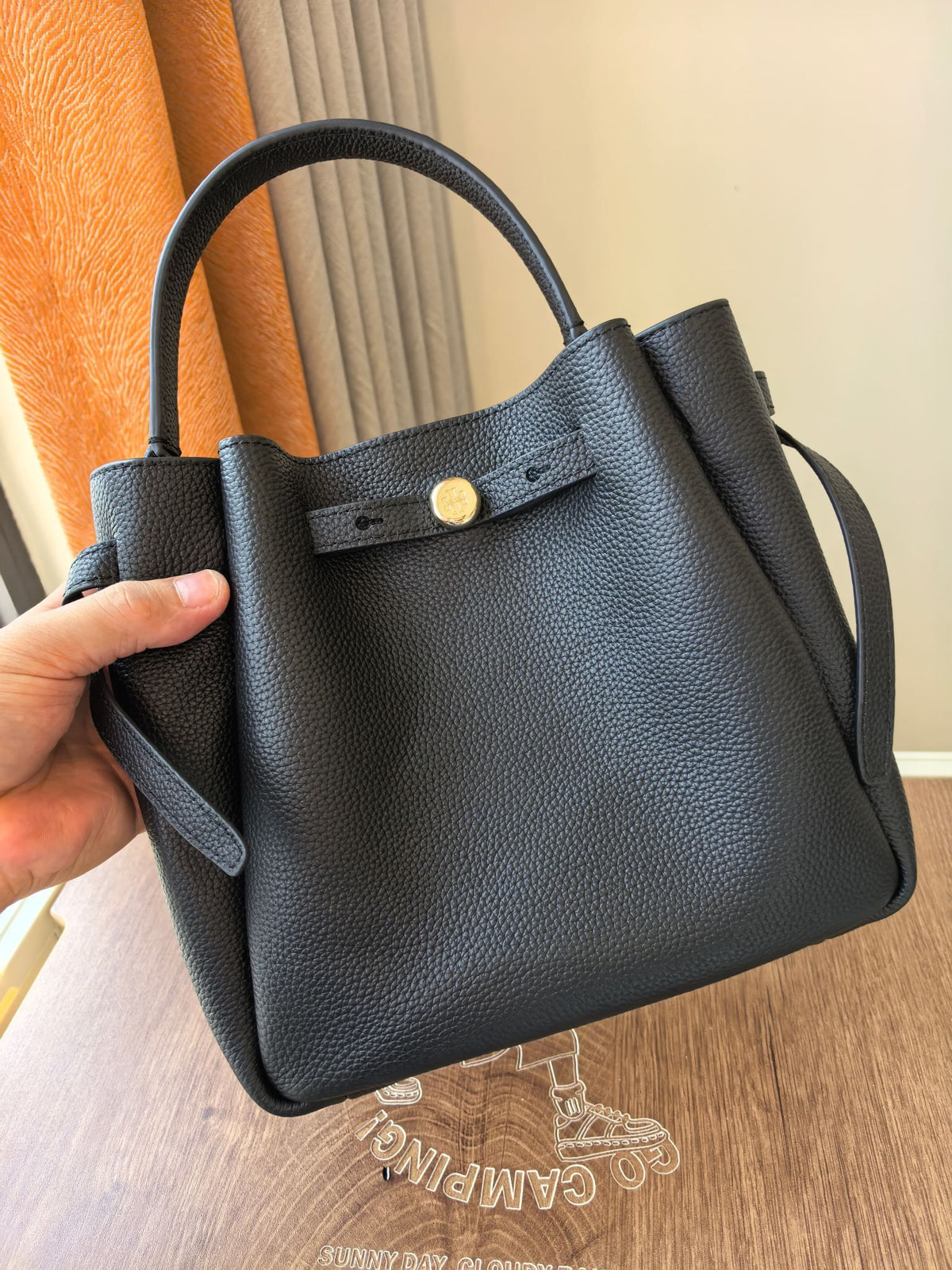 Toryburch's brand new drawstring shopping tote bag with serial number 923 ROMY is a portable crossbody bucket bag made of delicate and thick cowhide material with a soft waist contour. It is the ultimate daily handbag with light weight and spacious interi