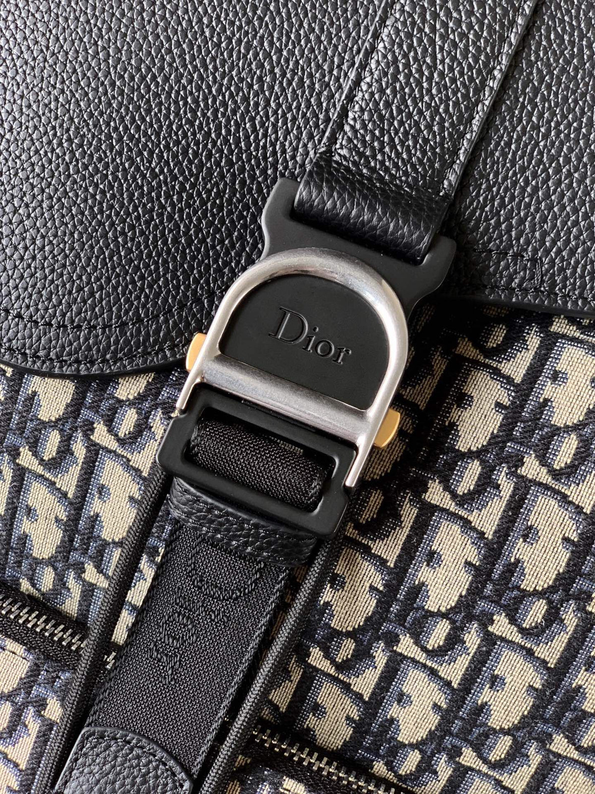 The Heritage Saddle Flap Backpack features a stylish original design that accentuates your saddle style. Crafted from beige and black Oblique print fabric with black grained calf leather details. A spacious compartment under the saddle flap embellished