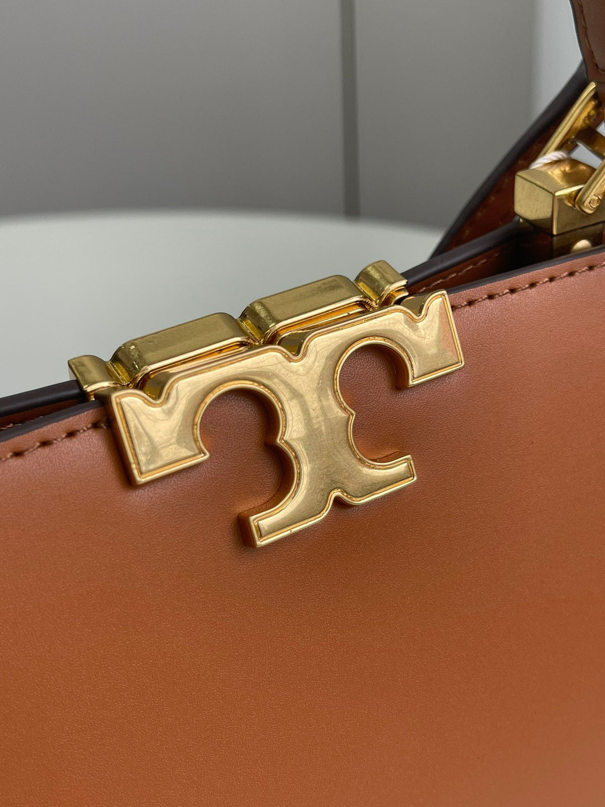 Number 086, TORY BURCH. New Eleanor leather handbag with exquisite suede trim. The bag has a clean and crisp body, and the iconic double T logo is three-dimensional and eye-catching. Exquisite craftsmanship. It can be lifted with a handle or removed