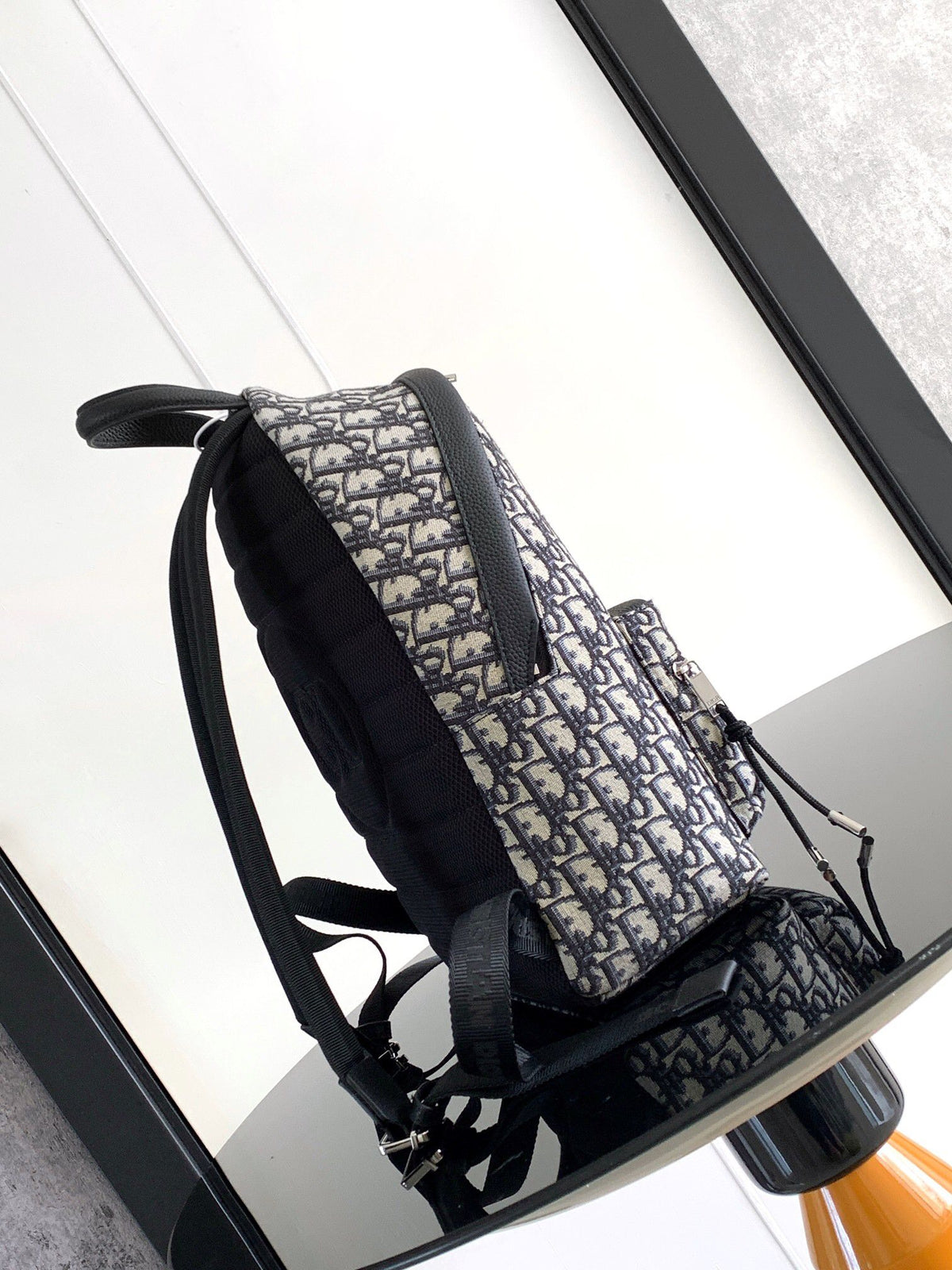 Under the small black lettering. This Rider backpack has a simple silhouette. The classic collegiate style is full of energy. Inspired by the Dior men's collection. Reinterpreted in beige and blue jacquard fabrics. Oblique print throughout. Continuing