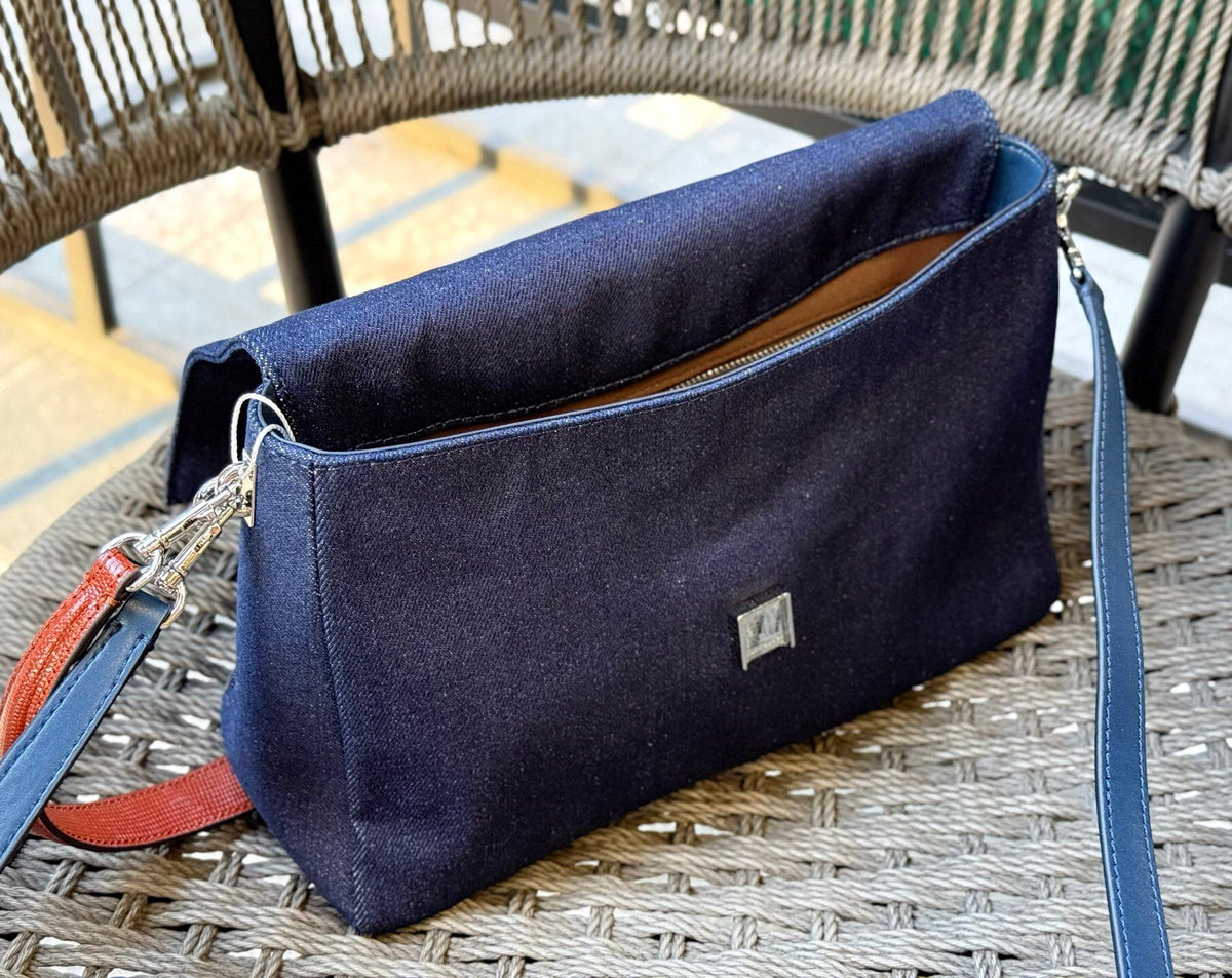 Denim TORY BURCH CHARLE DRNIM SHOULDER BAG denim underarm bag with deep blue denim and contrasting caviar patterned shoulder straps, simple yet textured. The front double T metal logo is highly recognizable, and the underarm back or single shoulder crossb