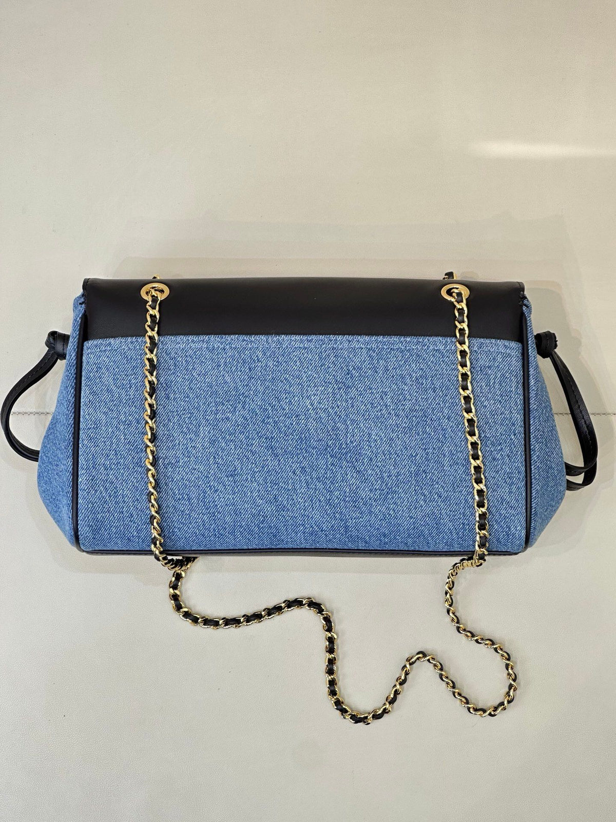 Denim blue. The main body is stone-washed blue denim fabric. The texture of the fabric is clear. It is a natural and soft denim blue. It is not too bright blue. The upper cover is spliced with black smooth first-layer cowhide. The tough denim and the