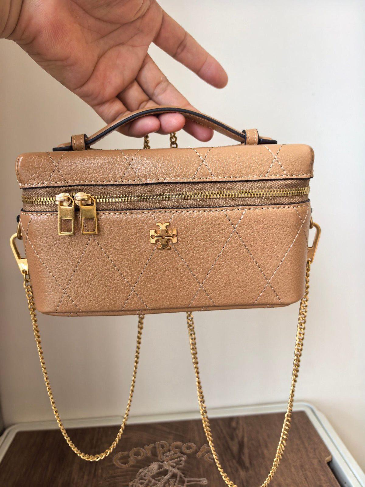 Apricot TORY BURCH KIRA DIAMOND QUILT CHARM EAST-WEST VANITY CASE diamond box bag is made of quilted cowhide with iconic double T metal logo, simple yet recognizable. The chain shoulder strap can be carried diagonally or carried on one shoulder, flexible