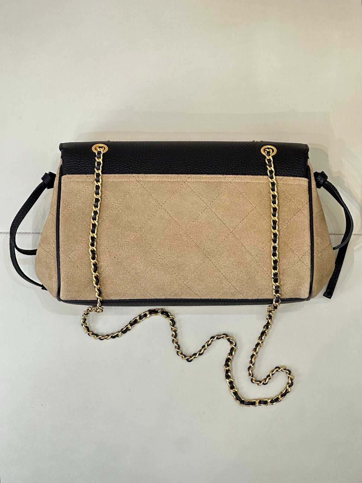 The main body of the apricot bag is made of fine khaki suede. The surface layer has even and soft fluff, with a matte matte texture. It has a retro and old atmosphere. The upper cover is spliced with black grained cowhide. The collision of soft and
