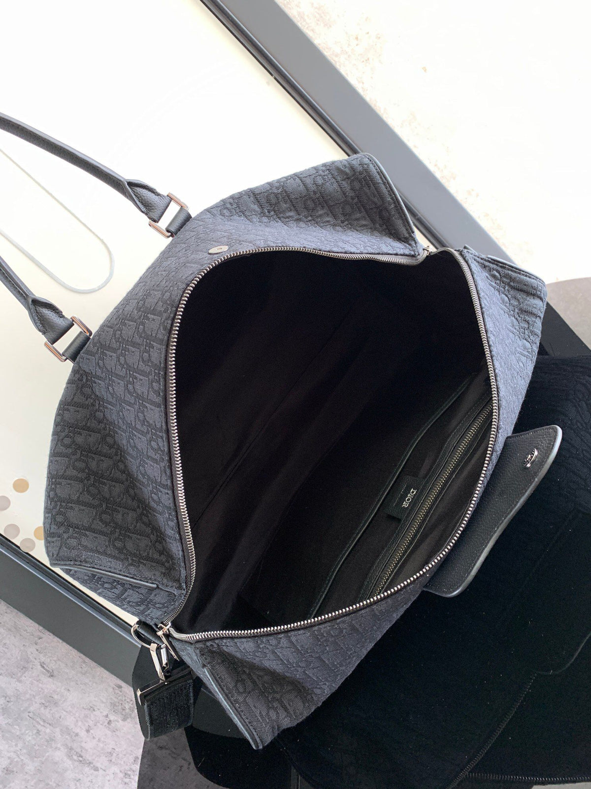 This Dio Lingot 50 handbag is new this season. Practical and elegant, unique. Crafted from black Oblique jacquard fabric. With black grained calfskin leather details to enhance the style. Decorated with DIO logo on the front. Zippered compartment with