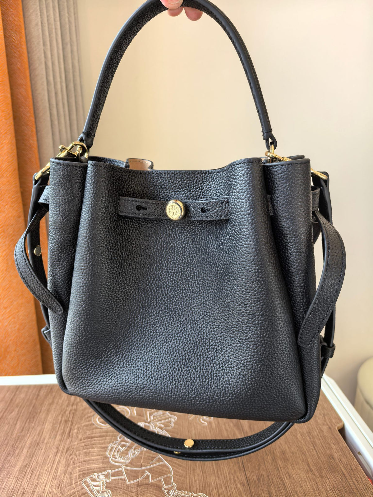 Toryburch's brand new drawstring shopping tote bag with serial number 923 ROMY is a portable crossbody bucket bag made of delicate and thick cowhide material with a soft waist contour. It is the ultimate daily handbag with light weight and spacious interi