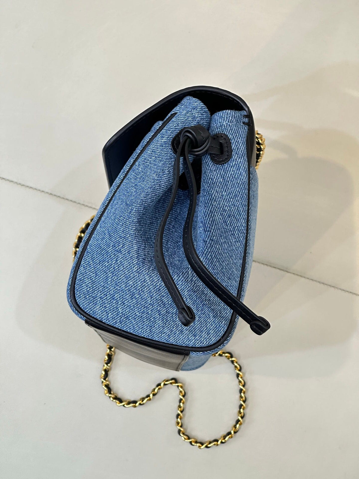 Denim blue. The main body is stone-washed blue denim fabric. The texture of the fabric is clear. It is a natural and soft denim blue. It is not too bright blue. The upper cover is spliced with black smooth first-layer cowhide. The tough denim and the