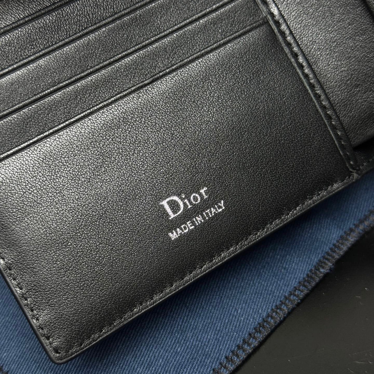 This bifold wallet is a compact accessory. Sophisticated and elegant. Crafted from grained calfskin. CD logo on the front. Features a double cash compartment on the interior. Two bill pockets and eight card slots. Bifold style fits easily into a pocket