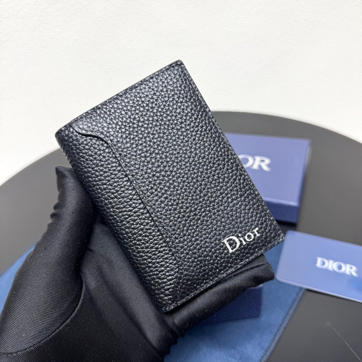 This vertical bifold card holder is elegant and practical. It is crafted from grained cow leather. It is decorated with the CD logo on the front. It has three card slots on each side and two receipt pockets. It is exquisite and elegant. It can be easily
