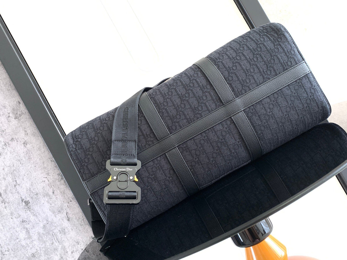 This Dio Lingot 50 handbag is new this season. Practical and elegant, unique. Crafted from black Oblique jacquard fabric. With black grained calfskin leather details to enhance the style. Decorated with DIO logo on the front. Zippered compartment with
