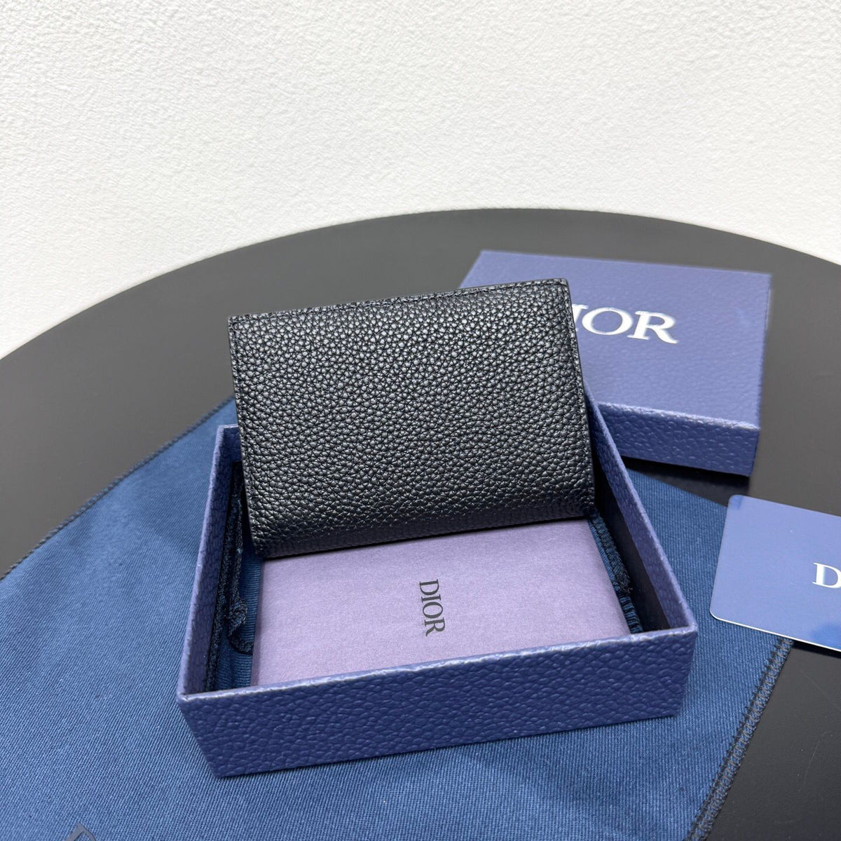 This vertical bifold card holder is elegant and practical. It is crafted from grained cow leather. It is decorated with the CD logo on the front. It has three card slots on each side and two receipt pockets. It is exquisite and elegant. It can be easily