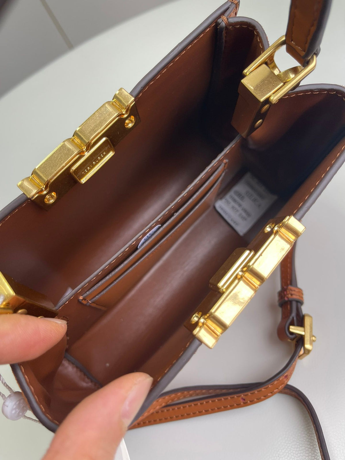 Number 086, TORY BURCH. New Eleanor leather handbag with exquisite suede trim. The bag has a clean and crisp body, and the iconic double T logo is three-dimensional and eye-catching. Exquisite craftsmanship. It can be lifted with a handle or removed