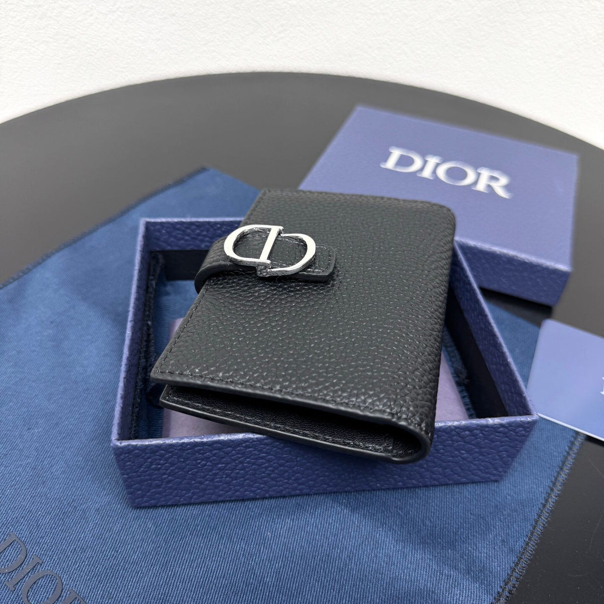 This vertical bifold card holder is elegant and practical. It is crafted from grained cow leather. It is decorated with the CD logo on the front. It has three card slots on each side and two receipt pockets. It is exquisite and elegant. It can be easily