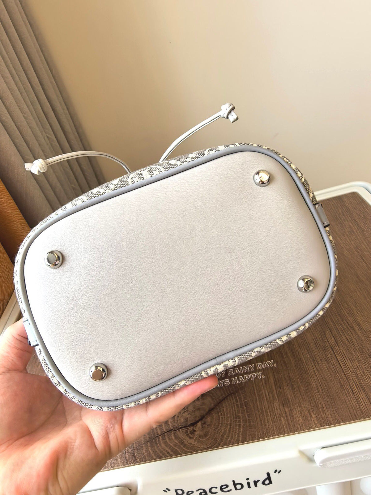 ToryBurch's new 1615A vintage water bucket bag features a classic TMonogram pattern fused with jacquard fabric, creating a charming and timeless style. This bucket bag is adorned with delicate leather trim, a top handle, and a detachable diagonal strap