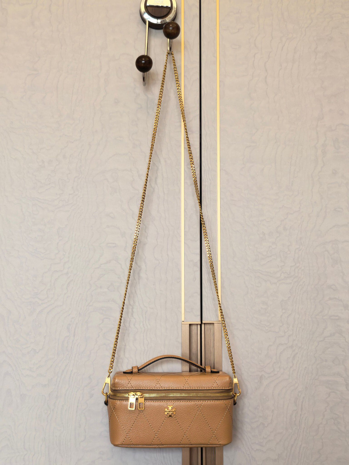 Apricot TORY BURCH KIRA DIAMOND QUILT CHARM EAST-WEST VANITY CASE diamond box bag is made of quilted cowhide with iconic double T metal logo, simple yet recognizable. The chain shoulder strap can be carried diagonally or carried on one shoulder, flexible