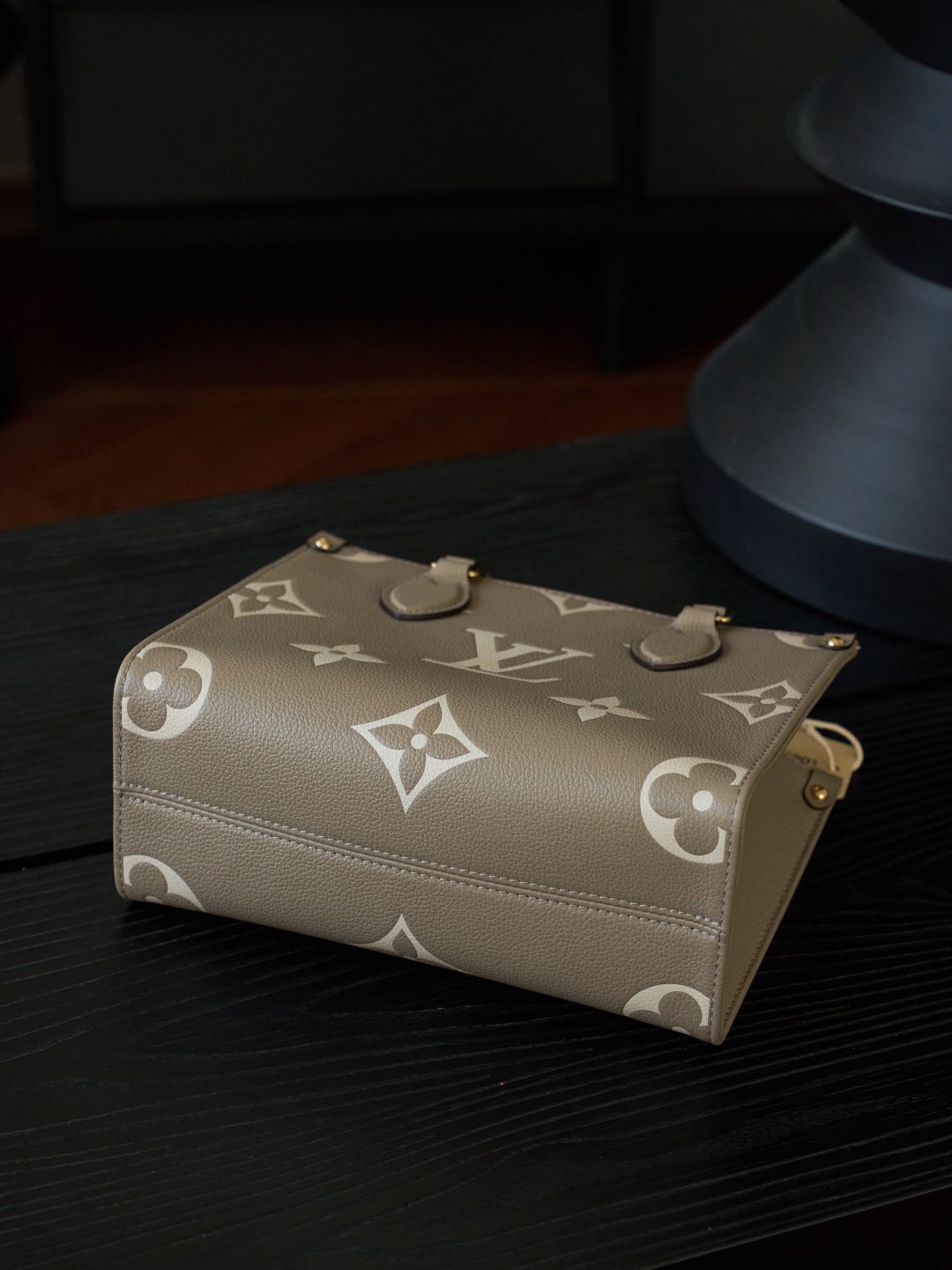 ONTHEGO Small Handbag M45779 This OnTheGo Small Tote Bag draws inspiration from the Sac Plat handbag, which was born in 1968, and incorporates Monogram Empreinte leather with Medium Bicolor Monogram embossing for a slightly smaller size. The original