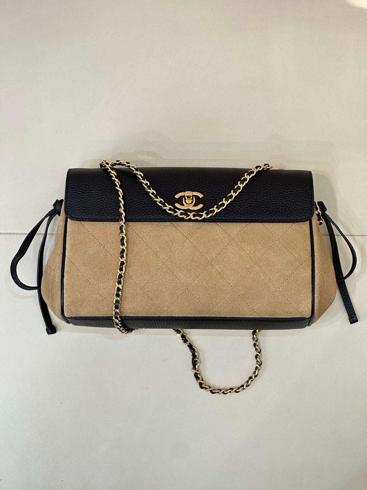 The main body of the apricot bag is made of fine khaki suede. The surface layer has even and soft fluff, with a matte matte texture. It has a retro and old atmosphere. The upper cover is spliced with black grained cowhide. The collision of soft and