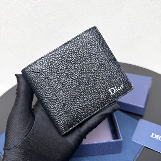This bifold wallet is a compact accessory. Sophisticated and elegant. Crafted from grained calfskin. CD logo on the front. Features a double cash compartment on the interior. Two bill pockets and eight card slots. Bifold style fits easily into a pocket